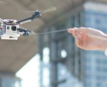 Minyatür insansız hava aracı tasmasıyla uçuyor